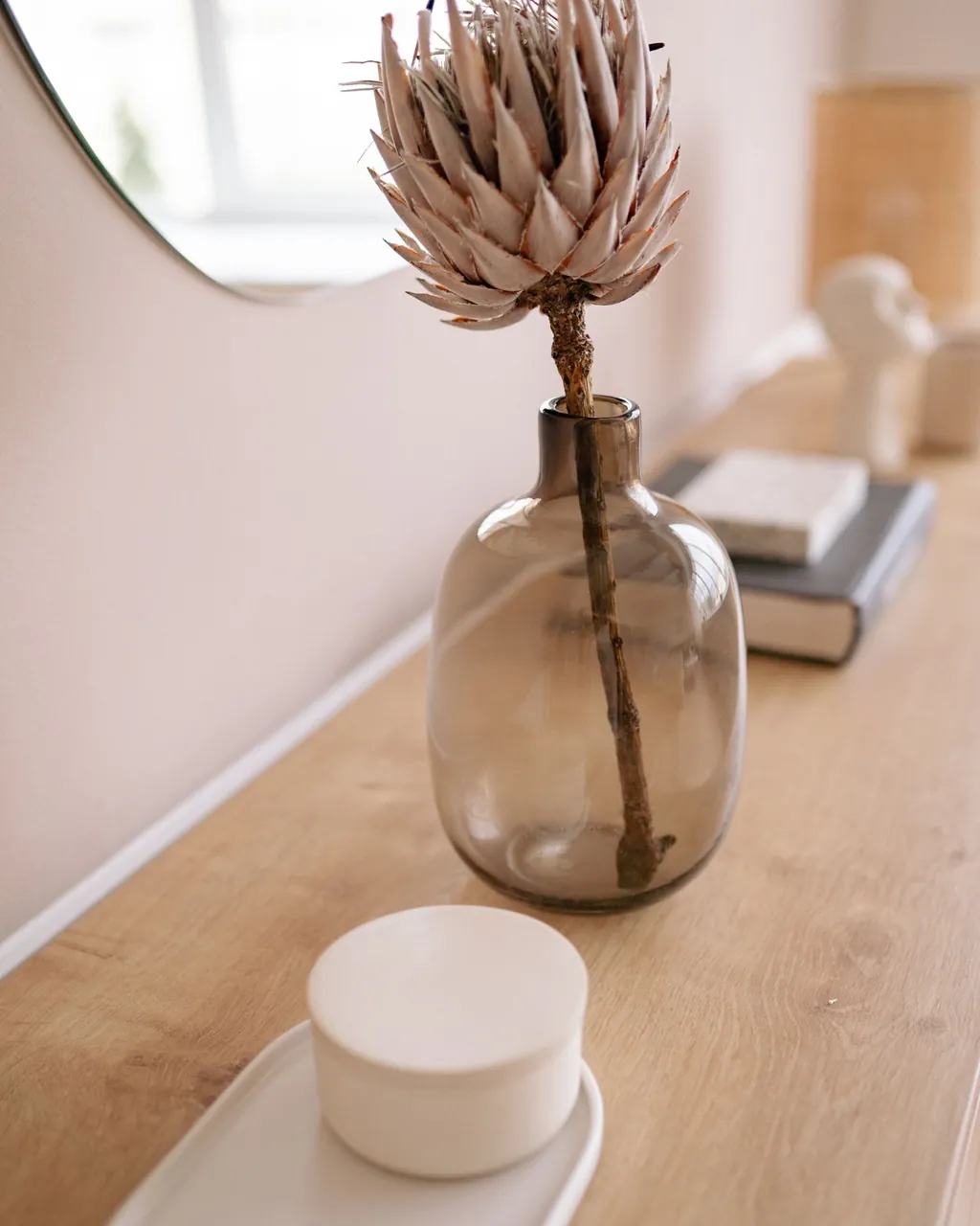 Smoked glass vase with a dried protea and a ceramic box on a wooden console — home decor and gifts for wholesalers selling B2B with their VentasxMayor store