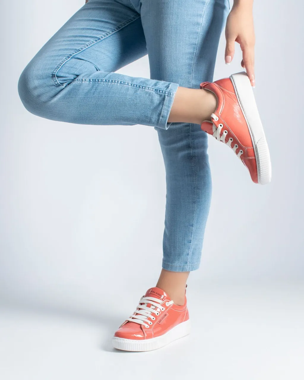 Coral patent leather sneakers with white soles and light-blue jeans — footwear for manufacturers and distributors selling wholesale with their B2B VentasxMayor store