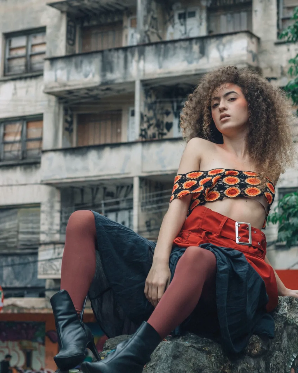 Model wearing an orange and black crochet top, red belted skirt and black boots — fashion apparel for clothing wholesalers selling B2B with their VentasxMayor wholesale store